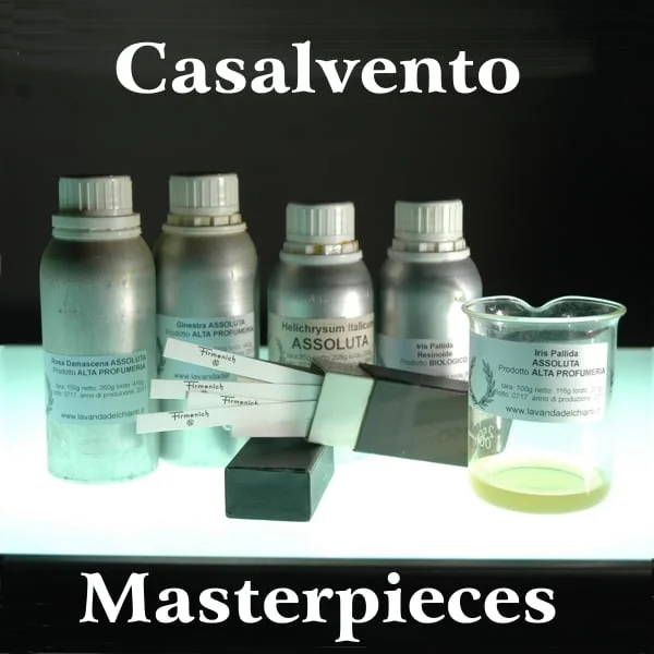 A glass beaker with a yellow liquid and four aluminum bottles with a white plastic cap with a label on a black background resting on an illuminated surface, Written. masterpieces of Casalvento